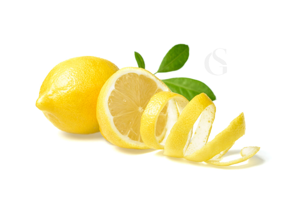 lemon sliced in a circular pattern where the peel falls to the right, full lemon and leaves behind, white background
