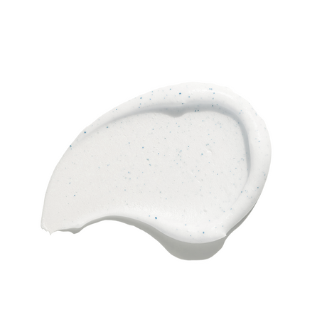 White cream skincare swatch with blue speckles on a white background