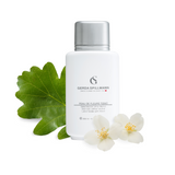 White bottle with silver cap labeled 'Gerda Spillmann' on a white background with green leaf and white flowers.